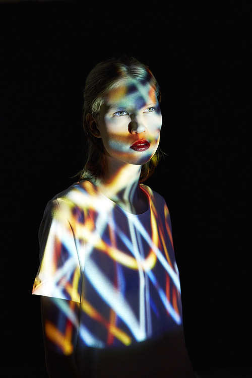 Young Woman covered in multicolored lights